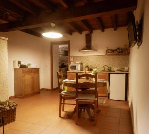 a kitchen and dining room with a table and a microwave at Casa Abraao by AL Belmonte in Belmonte