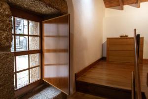 um quarto com uma porta de madeira e uma janela em Casa Abraao em Belmonte