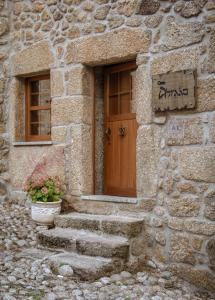 a stone building with a wooden door and stairs at Casa Abraao in Belmonte