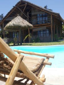 un complexe avec une piscine et une cabane en paille dans l'établissement Baraka Beach Vilanculos, à Vilanculos