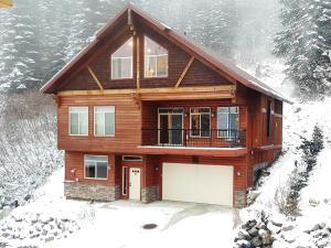 une maison avec un garage dans la neige dans l'établissement Crystal Springs Chalet, à Sandpoint