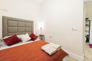 マドリードにあるApartamento en Calle Relatoresのベッドルーム1室(大型ベッド1台、赤と白の枕付)
