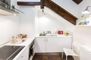 a white kitchen with white cabinets and a sink at Apartamento en Calle Relatores in Madrid