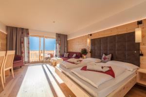 una grande camera da letto con due letti e una grande finestra di Hotel Schopfenhof a San Candido