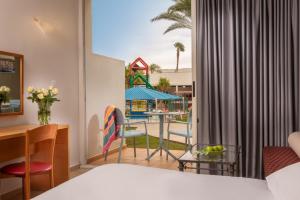 een hotelkamer met een bed en een tafel en stoelen bij Leonardo Club Eilat - All Inclusive in Eilat