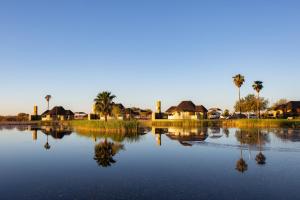 a view of a lake with houses and palm trees at Lapa Lange Game Lodge in Mariental