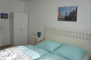 ReppenstedtにあるPrivatzimmer Sutantoのベッドと壁に絵が飾られた寝室