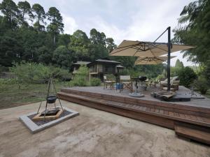 un patio con sombrilla, mesa y sillas en 森と空と家 Spacious private house Moritosora, en Sanmu