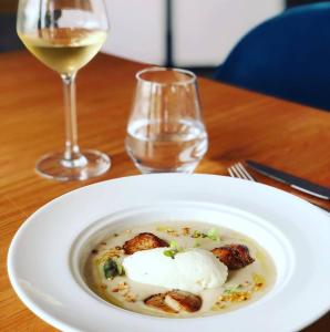 a white plate of food and a glass of wine at Le Spinaker in Le Grau-du-Roi