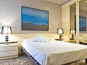 een slaapkamer met een groot wit bed en 2 lampen bij APARTMENT SALOU MAIN BEACH in Salou