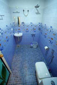 ein blau gefliestes Bad mit WC und Waschbecken in der Unterkunft Marari Sabari Home Stay in Mararikulam