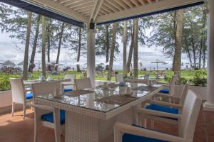 a dining room with tables and chairs and a view of the ocean at Dusit Thani Laguna Phuket in Bang Tao Beach