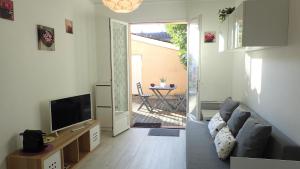 sala de estar con sofá y TV en Clos Saint Médard en Saint-Médard-en-Jalles