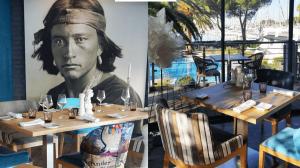 a painting of a man sitting at a table in a restaurant at Le Spinaker in Le Grau-du-Roi