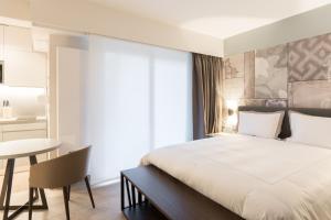ルクセンブルクにあるThe Residence Gareのベッドとテーブルが備わるホテルルームです。