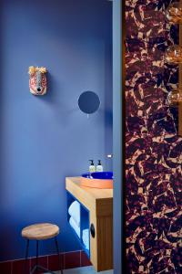 a blue bathroom with a sink and a stool at 25hours Hotel Terminus Nord in Paris