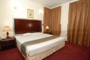 a bedroom with a large bed in a hotel room at Royal Plaza Hotel Apartments in Dubai