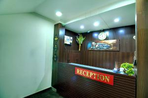 einen Empfangsraum mit einer Rezeption und einer Uhr in der Unterkunft STAAYZ Premium Gurgaon in Gurgaon