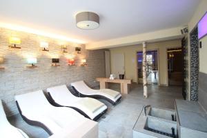 a living room with two white couches and a brick wall at Parkhotel Emstaler Höhe in Bad Emstal