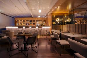a restaurant with tables and chairs and a bar at Dar El Marsa Hotel & Spa in La Marsa