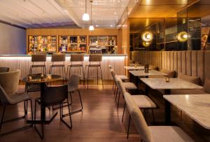 a restaurant with tables and chairs and a bar at Dar El Marsa Hotel & Spa in La Marsa