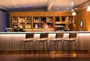 a bar with four stools in front of it at Dar El Marsa Hotel & Spa in La Marsa