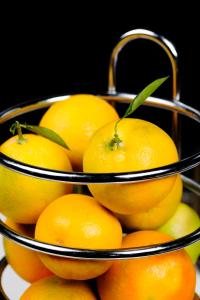 a pile of oranges in a metal basket at Dar El Marsa Hotel & Spa in La Marsa