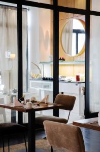a dining room with a table and chairs and a mirror at Dar El Marsa Hotel & Spa in La Marsa
