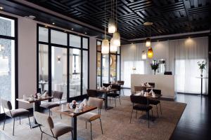 a restaurant with tables and chairs and windows at Dar El Marsa Hotel & Spa in La Marsa