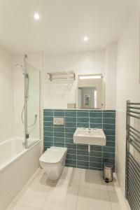 a bathroom with a toilet and a sink and a shower at 17 Woolacombe The Byron in Woolacombe