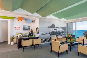 um escritório com uma sala de espera com cadeiras e uma secretária em Aqua Natura Madeira em Porto Moniz