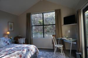 um quarto com uma cama, uma secretária e uma janela em Haven Sanctuary Suite with Private Entrance em Queenstown