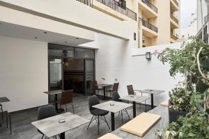 um restaurante com mesas, cadeiras e plantas em Mr Todd Hotel em Sliema