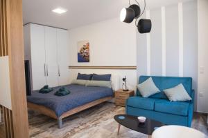 a bedroom with a bed and a blue couch at Leiland #colony_White_Tower_Suite in Thessaloniki