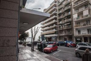 a city street with cars parked in front of tall buildings at Leiland #colony_White_Tower_Suite in Thessaloniki