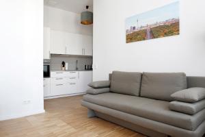 sala de estar con sofá y cocina en SC 3 Cozy Family & Business Flair welcomes you - Rockchair Apartments, en Berlín