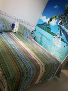 a bedroom with a bed with a painting of a beach at Barra da Tijuca Resort Bora Bora in Rio de Janeiro