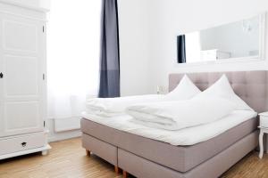 a bed with white sheets and pillows in a room at SC 3 Cozy Family & Business Flair welcomes you - Rockchair Apartments in Berlin