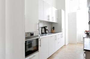 a kitchen with white cabinets and a stove top oven at SC 4 Cozy Family & Business Flair welcomes you - Rockchair Apartments in Berlin