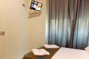 a bedroom with a bed and a tv on the wall at Hotel Midtown Milano in Milan