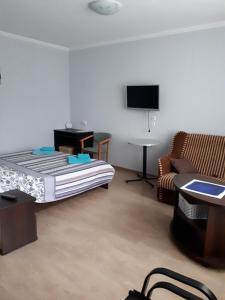 a room with a bed and a couch and a tv at Casablanca Guest House in Koktebel