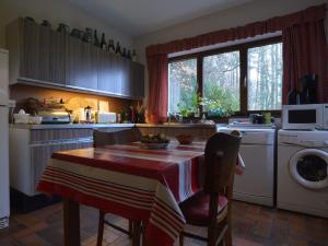 cocina con mesa y lavadora en Amazing Chalet in Stavelot with Garden en Stavelot