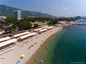 a beach with umbrellas and people in the water at Privetlivy bereg in Gelendzhik