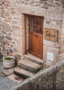 uma entrada para um edifício de pedra com uma porta de madeira em Casa Miriam em Belmonte