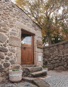 a stone building with a wooden door and a stone wall at Casa Miriam in Belmonte