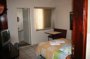 サン・カエタノ・ド・スルにあるHotel Capriccio São Caetanoのベッドとバスルーム付きのホテルルームです。