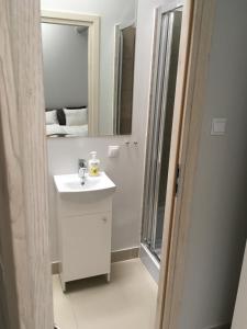 a white bathroom with a sink and a mirror at Mia Mia House in Katowice
