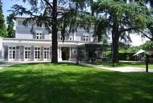 埃居里的住宿－丹托亞德莊園酒店，一座白色的大建筑,前面有一个绿色的草坪