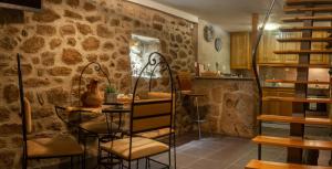 a room with a table and chairs and a stone wall at Casa dos Poetas by AL Belmonte in Belmonte