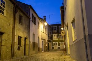 an empty alley with buildings and a street sign at night at Casa dos Poetas in Belmonte